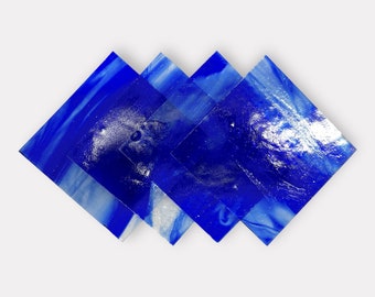May include: Five square, blue glass tiles arranged in a diamond shape. The tiles have a marbled appearance with shades of blue and white. The glass is translucent, allowing light to pass through, and has a glossy finish.