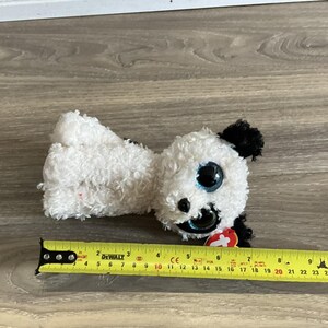 May include: White and black plush dog toy with blue eyes and a red tag that says "Ty".