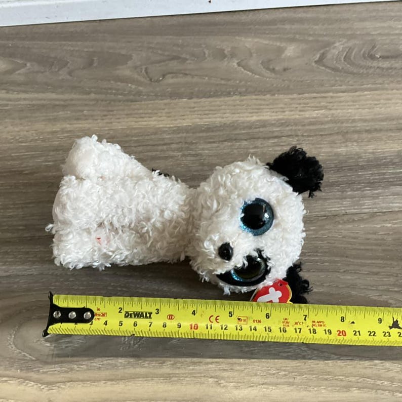 May include: White and black plush dog toy with blue eyes and a red tag that says "Ty".