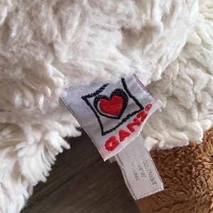 Pu&ograve; includere: Peluche bianco e marrone con un logo a forma di cuore rosso che dice "Ganz" sull'etichetta.