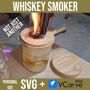 Può includere: Un affumicatore per whisky in legno con un coperchio e un bicchiere di whisky all'interno. L'affumicatore viene acceso con un cannello. Il testo "NOT JUST ANOTHER" è visibile nell'immagine. Il testo "SVG + VCarve PRO" è anche visibile nell'immagine.