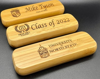 May include: Three wooden boxes with engraved text and logos. The top box says "Mike Tyson Class of 2022" and has a crest with the word "Calvary". The middle box says "Class of 2022" and has a crest with the words "High Hill Academy". The bottom box says "University of North State" and has a building illustration.