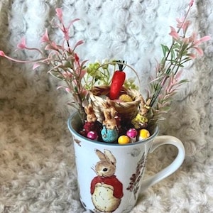 Jardín de Pascua en miniatura de Peter Rabbit en una taza de té