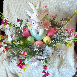 Mama and baby bunny in a pail, with assorted flowers atop a candlestick. gorgeous Easter centerpiece.