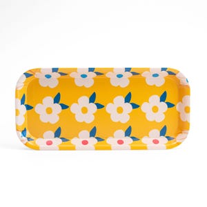 May include: A yellow rectangular tray with a floral pattern. The tray has white flowers with blue leaves and pink centers.