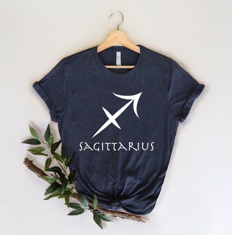 May include: A dark blue t-shirt with a white Sagittarius zodiac symbol and the word "SAGITTARIUS" printed on the front.