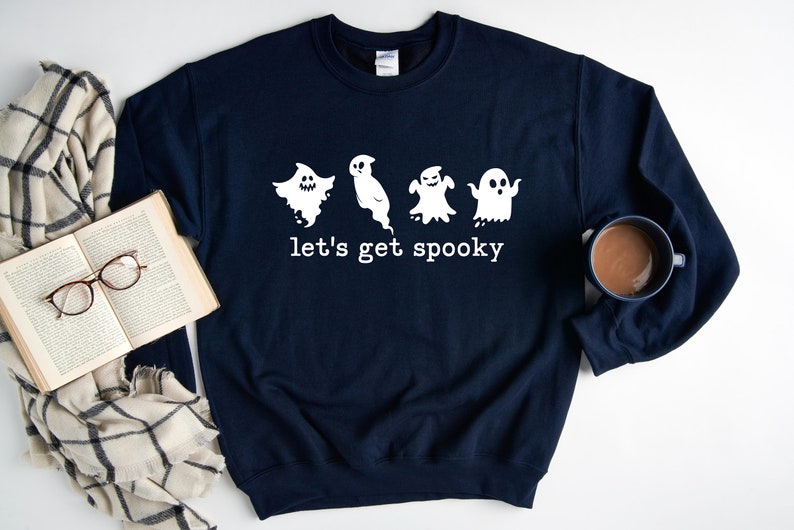 May include: A navy blue sweatshirt with a white graphic of four ghosts and the text "let's get spooky".