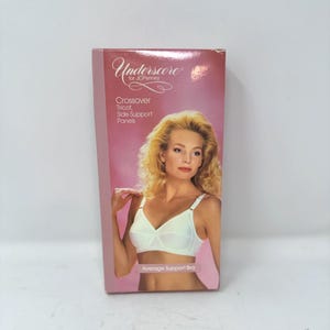 May include: A rectangular product box for an Underscore for JCPenney average support bra. The packaging is pink with white text reading Crossover, Tricot, Side Support Panels. It features a photograph of a person wearing a white bra.