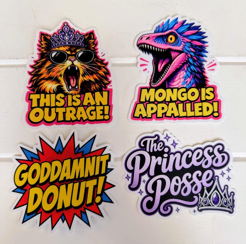 May include: Four colorful stickers featuring a cat wearing a crown and sunglasses with the text THIS IS AN OUTRAGE, a dinosaur with the text MONGO IS APPALLED, a comic-style burst with the text GODDAMNIT DONUT, and the text The Princess Posse with a crown.