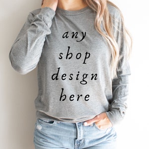 May include: A heather gray long-sleeved sweatshirt with the text "any shop design here" printed on the front.