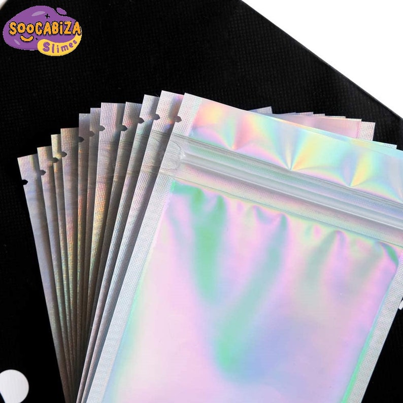 K&ouml;nnte beinhalten: Ein Stapel irisierender, holografischer Plastik-Rei&szlig;verschlussbeutel mit wei&szlig;em Rei&szlig;verschluss. Die Beutel sind f&auml;cherf&ouml;rmig angeordnet und alle gleich gro&szlig;. Die Beutel eignen sich perfekt zum Verpacken von kleinen Gegenst&auml;nden wie Schmuck, S&uuml;&szlig;igkeiten oder Bastelarbeiten.