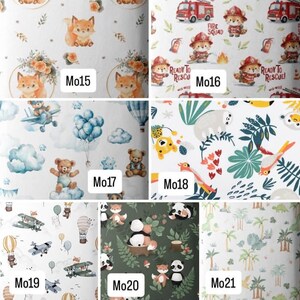 Op de afbeelding: Een collage van zeven stofpatronen gelabeld van Mo15 tot Mo21. De ontwerpen bevatten vossen met bloemenkransen, brandbestrijdende dieren met brandweerwagens, teddyberen met ballonnen en vliegtuigen, jungledieren, luchtvaartmotieven, panda's en palmbomen.