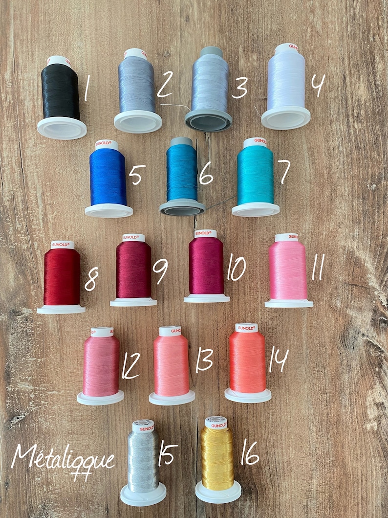 May include: Sixteen spools of Gunold embroidery thread arranged in four rows, numbered 1 through 16. The colors include black, various shades of gray, white, blue, teal, red, magenta, pink, coral, orange, silver, and gold metallic thread.