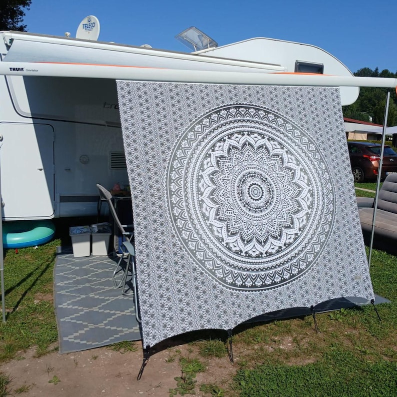 May include: A gray and white patterned awning with a large mandala design. The awning is attached to a white camper van.