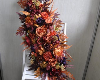 Guirnalda floral de color óxido, burdeos y morado: decoración bohemia para bodas de otoño.