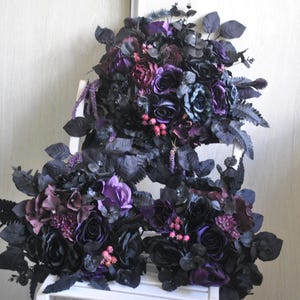 May include: Three bouquets of artificial flowers in shades of purple and black. The bouquets are made of silk flowers and greenery and are arranged in a cascading style.