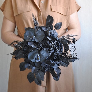 May include: A black wedding bouquet with roses, orchids, and ferns.