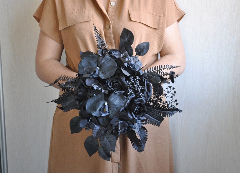 May include: A black wedding bouquet with roses, orchids, and ferns.
