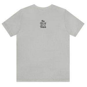 May include: A light grey t-shirt with the text "The Chi-est Part of Town" printed on the back.