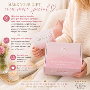 May include: A light pink gift box with the text 'YOU DESERVE THIS MOMENT' and 'A Gift of Self-Love' printed on the front. The box is held by hands and accompanied by a small card that reads 'JUST FOR YOU with love' in elegant script.