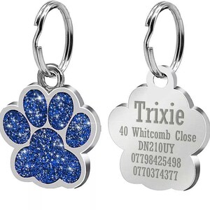 May include: A silver dog tag with a blue glitter paw print on one side and the text "Trixie", "40 Whitcomb Close", "DN210UY", "07798425498", and "0770374377" on the other side.