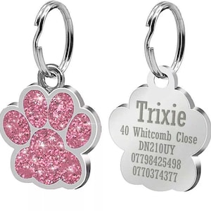 May include: Pink glitter paw print dog tag with silver ring and engraved text: Trixie, 40 Whitcomb Close, DN210UY, 07798425498, 0770374377.