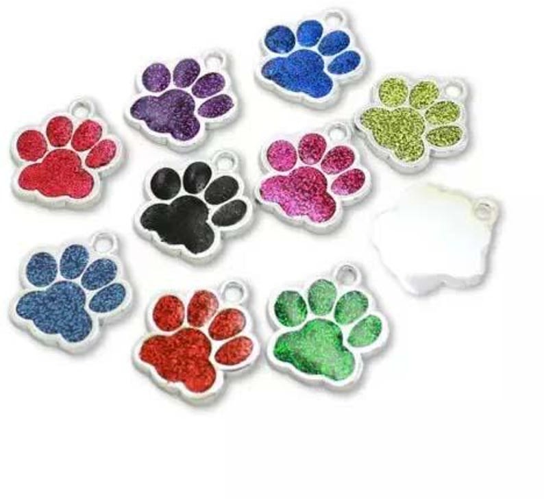 May include: Assortment of ten silver paw print charms with glitter accents. The charms are in various colors, including red, blue, green, pink, purple, and black.