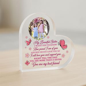 May include: A heart-shaped acrylic photo frame with a pink butterfly design and the text "My Beautiful Sister I want you to know How proud I am of you And how much I love you so I will love you and support you Right till the end You are more than a sister You are my best friend".