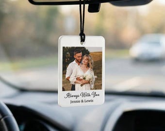 Könnte beinhalten: Ein rechteckiger weißer Auto-Lufterfrischer mit einem Foto eines Paares, das sich umarmt. Der Text "Always With You" und Namen sind unter dem Foto aufgedruckt. Der Lufterfrischer hängt an einer schwarzen Schnur, die am Rückspiegel eines Autos befestigt ist.