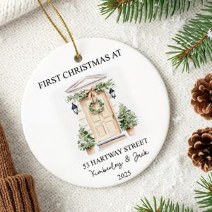 Puede incluir: Adorno navide&ntilde;o de cer&aacute;mica blanca con el texto &laquo;&nbsp;FIRST CHRISTMAS AT&nbsp;&raquo; y una ilustraci&oacute;n de acuarela de una puerta principal. El adorno tambi&eacute;n incluye la direcci&oacute;n &laquo;&nbsp;53 HARTWAY STREET&nbsp;&raquo; y los nombres &laquo;&nbsp;Kimberley & Jack&nbsp;&raquo; con el a&ntilde;o &laquo;&nbsp;2025&nbsp;&raquo;.