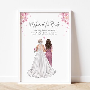 May include: Framed print with the text "Mother of the Bride" and a bride in a white gown and her mother in a pink dress. The image includes pink floral accents and a touching message, perfect for a wedding gift.