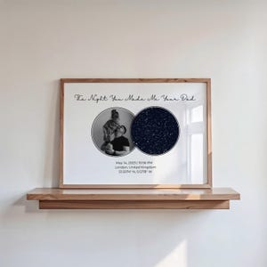 May include: A framed print with a wooden frame, featuring a black and white photo of a parent and child, and a star map. The text "The Night You Made Me Your Dad" is at the top, with date and location details below.