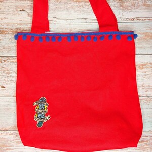 Divertida bolsa de lona roja: parche bordado y pompones azules