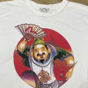 May include: White t-shirt with a red circle graphic featuring a cartoon character holding a fan and a fish. The character is wearing a green hat and a white and blue outfit. The text "福" is visible on the graphic.