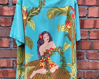 May include: A turquoise blue short-sleeved shirt with a tropical print featuring a woman in a red and yellow bikini, green leaves, and a brown woven basket.
