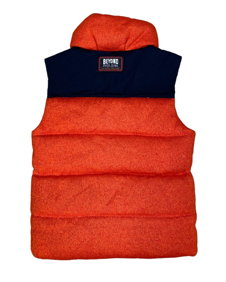 May include: Orange and navy blue puffer vest with a black label that reads "Beyond Evisu Jeans".