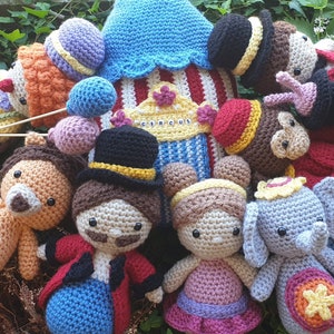 May include: A collection of crocheted stuffed animals, including a lion, a clown, an elephant, and a monkey. The animals are all wearing colorful costumes and are arranged in a circle around a small, crocheted circus tent.