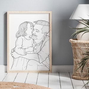 May include: A black and white line drawing of a father and daughter hugging. The daughter is kissing the father on the cheek. The drawing is framed in a light wood frame.