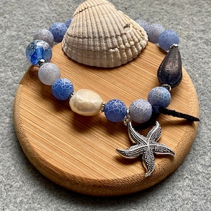 Silver starfish charm bracelet with blue fire agate and a baroque pearl