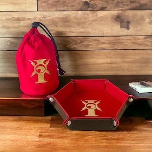 May include: Red dice bag with a gold logo of a stylised animal head with lightning bolts and the letter I. A red hexagonal dice tray with the same logo.