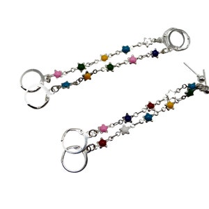 May include: Silver earrings featuring a double chain design. Each chain is decorated with colourful star-shaped beads in pink, blue, green, yellow, and white. The earrings have a lever-back closure.
