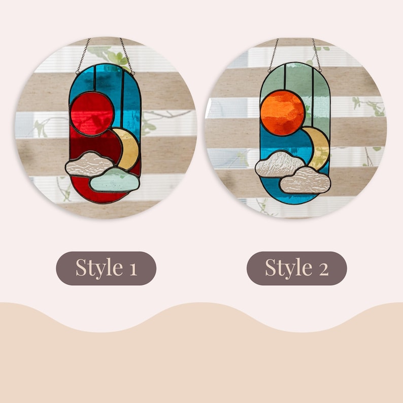 K&ouml;nnte beinhalten: Zwei Buntglas-Sonnen- und Mondmotive, eines mit einer roten Sonne und eines mit einer orangen Sonne. Beide Motive haben einen blauen Hintergrund, einen gelben Halbmond und wei&szlig;e Wolken.