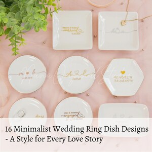 May include: A collection of minimalist white ring dishes in various shapes, including square, round, and hexagonal. Each dish features gold lettering with names, dates, or coordinates. The text "16 Minimalist Wedding Ring Dish Designs - A Style for Every Love Story" is displayed.