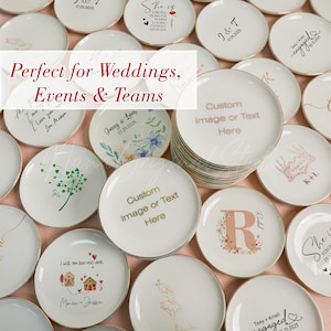 May include: A collection of round white ceramic trinket dishes with gold-toned rims, featuring various custom printed designs including floral patterns, calligraphy, dates, and the text Custom Image or Text Here and Perfect for Weddings, Events & Teams.