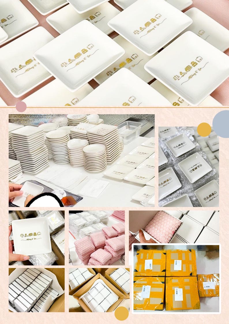 May include: A collection of white square ceramic dishes featuring a gold-colored graphic print of a house icon and the text "Always & Co". The dishes are shown in various stages of organization, including stacked piles, individual pieces, and packed boxes.