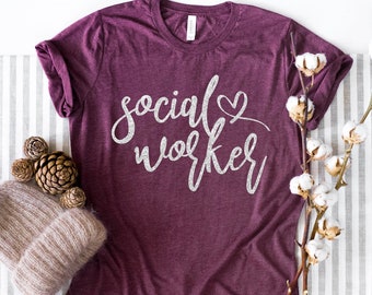 May include: A maroon t-shirt with the text "social worker" in white glitter lettering and a small heart.