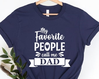 May include: Navy blue t-shirt with white text that reads "My Favorite People call me Dad" with a heart symbol in the word "People".