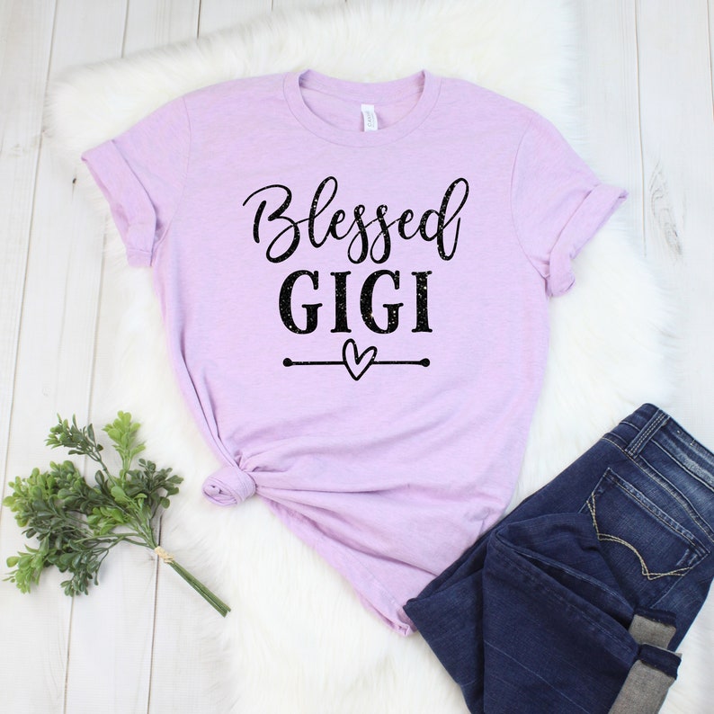 May include: A lavender t-shirt with the text "Blessed Gigi" in black lettering with a small heart graphic.