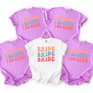 Puede incluir: Cinco camisetas de manga corta. Cuatro son de color lavanda y llevan la inscripci&oacute;n "I DO CREW" en naranja, azul y rojo. La quinta es blanca y lleva la inscripci&oacute;n "BRIDE" en los mismos colores. Ideal para una despedida de soltera.