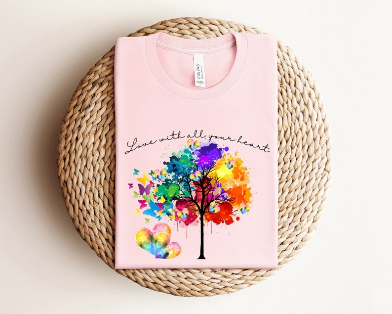 May include: Pink t-shirt with a colorful tree and butterflies, and the text "Love with all your heart".